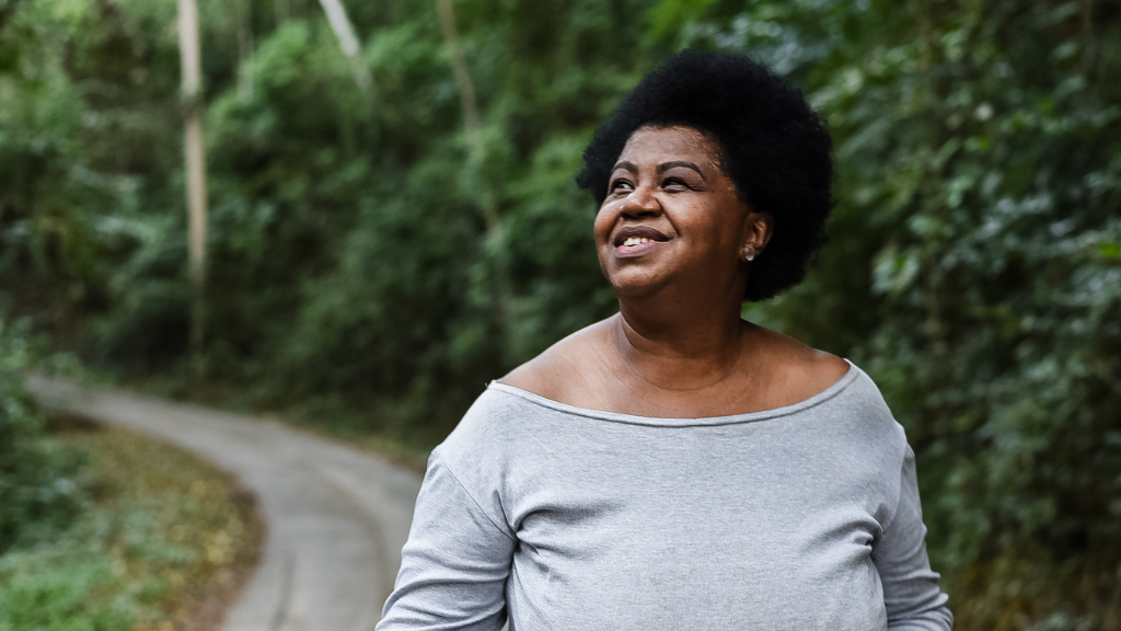 A woman is looking up and to the side happily.