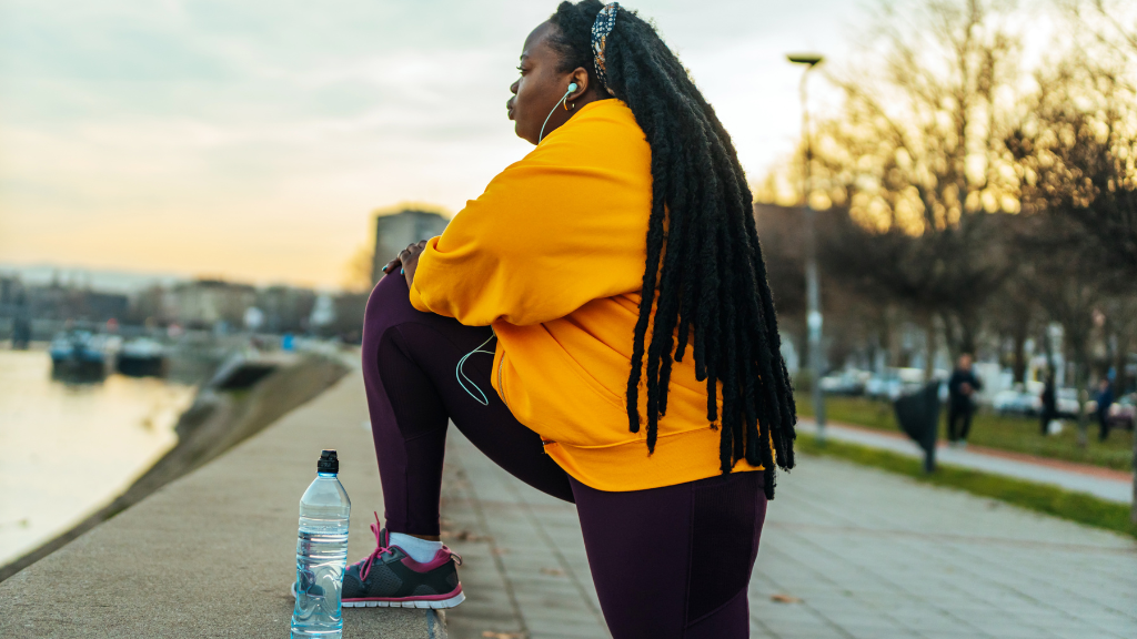 Woman in exercise clothes outdoors stretching